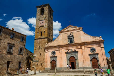 June 28, 2020 - Civita di Bagnoregio, Viterbo, Tuscia, Lazio, Italy - The Church of San Donato with the bell tower and the clock. Three wooden doors.のeditorial素材