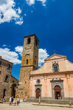 June 28, 2020 - Civita di Bagnoregio, Viterbo, Tuscia, Lazio, Italy - The Church of San Donato with the bell tower and the clock. Three wooden doors.のeditorial素材