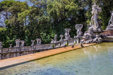 July 3, 2020 - Royal Palace of (Reggia di) Caserta - The large fountain of Aeolus with arches and marble statues. The water flows from above into a small waterfall. Fish in the big basin. Blue sky.のeditorial素材