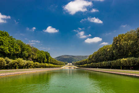 July 3, 2020 - Royal Palace of (Reggia di) Caserta - The large fountain of Aeolus with arches and marble statues. The water flows from above into a small waterfall. Fish in the big basin. Blue sky.のeditorial素材