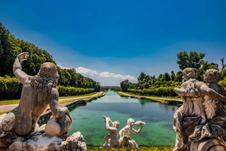 July 3, 2020 - Royal Palace of (Reggia di) Caserta - The large fountain of Aeolus with arches and marble statues. The water flows from above into a small waterfall. Fish in the big basin. Blue sky.のeditorial素材