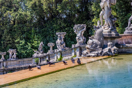 July 3, 2020 - Royal Palace of (Reggia di) Caserta - The very long basin of the park's artificial lake. The perspective view. The marble statues look and extend their hand towards the palace. Blue skyのeditorial素材