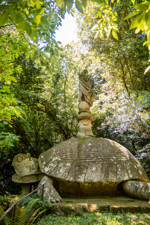 June 28, 2020 - Sacro Bosco (Sacred Grove) or Park of the Monsters of Bomarzo - Mannerist monumental garden. Echidna is a colossal woman with two snake tails instead of legs. Two lions.のeditorial素材