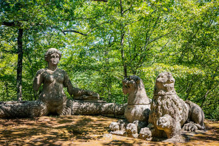 June 28, 2020 - Sacro Bosco (Sacred Grove) or Park of the Monsters of Bomarzo - Mannerist monumental garden. Echidna is a colossal woman with two snake tails instead of legs. Two lions.のeditorial素材