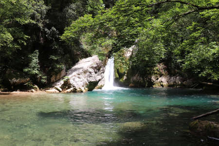The waterfall of San Benedetto in Subiaco, Rome, Lazio, Italy. Cool place, refreshment from summer heat. Trekking, mountain excursion. Peace, silence, nature. Some people sunbathe on the rocks.の写真素材