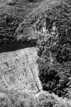 The lake of Salto, the largest artificial lake in Lazio, in the province of Rieti and created by damming the Salto river with the Salto dam. A sportsman practices water skiing towed by a motorboat.の写真素材