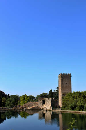 The Garden of Ninfa is a landscape garden in the territory of Cisterna di Latina, in the province of Latina, central Italy. View from the lake of the ruins of the ancient medieval castle.のeditorial素材