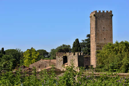 The Garden of Ninfa is a landscape garden in the territory of Cisterna di Latina, in the province of Latina, central Italy. View from the lake of the ruins of the ancient medieval castle.のeditorial素材