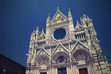 A glimpse of the medieval city of Siena, Tuscany, Italy. The majestic black and white marble cathedral with the campaniel and the large rose window.の写真素材