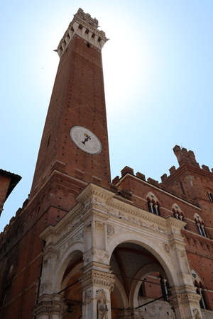 A glimpse of the medieval city of Siena, Tuscany, Italy. The Palazzo Pubblico with the Torre del Mangia in Piazza del Campo.の写真素材