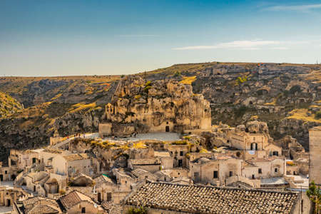 Matera, Basilicata, Italy - Panoramic view through a small slit, window, of the Sassi of Matera, Barisano and Caveoso. The ancient houses of stone and brick, carved into the rock. The ravine below.の写真素材