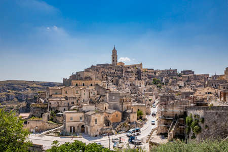 Matera, Basilicata, Italy - Panoramic view through a small slit, window, of the Sassi of Matera, Barisano and Caveoso. The ancient houses of stone and brick, carved into the rock. The ravine below.の写真素材