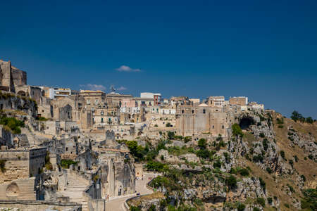 Matera, Basilicata, Italy - Panoramic view through a small slit, window, of the Sassi of Matera, Barisano and Caveoso. The ancient houses of stone and brick, carved into the rock. The ravine below.の写真素材