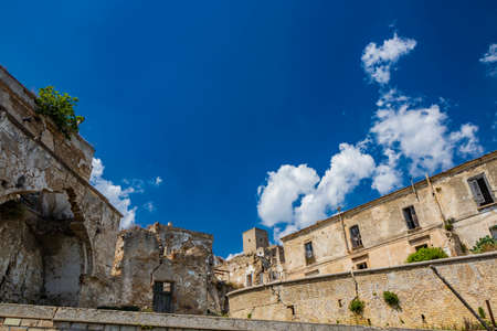 Craco, Matera, Basilicata, Italy. The ghost town destroyed and abandoned following a landslide. View of the remains and ruins of the ancient village built on the top of the hill. Watchtower at the topの写真素材
