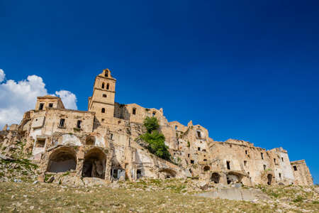 Craco, Matera, Basilicata, Italy. Ghost town destroyed and abandoned following a landslide. Collapsed houses and the remains invaded by vegetation. Broken walls, windows and doors, crumbling balconiesのeditorial素材
