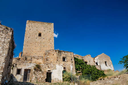 Craco, Matera, Basilicata, Italy. The ghost town destroyed and abandoned following a landslide. View of the remains and ruins of the ancient village built on the top of the hill. Watchtower at the topのeditorial素材