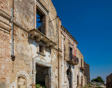 Craco, Matera, Basilicata, Italy. Ghost town destroyed and abandoned following a landslide. Collapsed houses and the remains invaded by vegetation. Broken walls, windows and doors, crumbling balconiesのeditorial素材