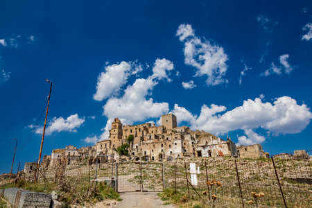 Craco, Matera, Basilicata, Italy. Ghost town destroyed and abandoned following a landslide. Collapsed houses and the remains invaded by vegetation. Broken walls, windows and doors, crumbling balconiesのeditorial素材