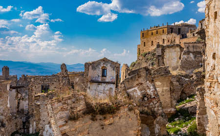 Craco, Matera, Basilicata, Italy. Ghost town destroyed and abandoned following a landslide. Collapsed houses and the remains invaded by vegetation. Broken walls, windows and doors, crumbling balconiesのeditorial素材