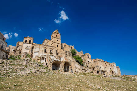 Craco, Matera, Basilicata, Italy. Ghost town destroyed and abandoned following a landslide. Collapsed houses and the remains invaded by vegetation. Broken walls, windows and doors, crumbling balconiesのeditorial素材