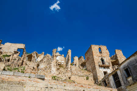 Craco, Basilicata, Italy. Ghost town destroyed and abandoned following a landslide. Collapsed houses and the remains invaded by vegetation. Broken walls, windows and doors. Bell tower of the churchのeditorial素材