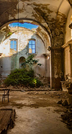 Craco, Basilicata, Italy. Ghost town destroyed and abandoned following a landslide. Collapsed houses and the remains invaded by vegetation. Broken walls, windows and doors. Bell tower of the churchのeditorial素材