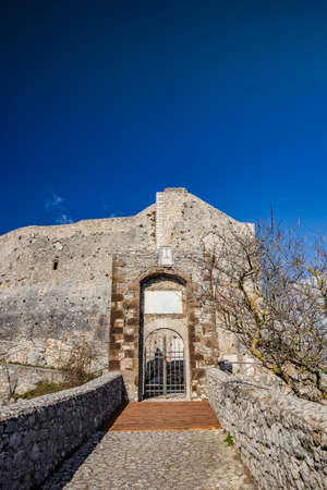 The small medieval village of Castel San Pietro Romano, Lazio, province of Rome, Palestrina. A glimpse of the town, with the small cobbled square. The ancient water well and the church bell tower.の写真素材