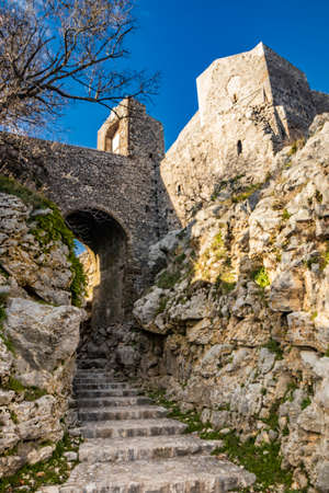 The small medieval village of Castel San Pietro Romano, Lazio, province of Rome, Palestrina. A glimpse of the town, with the small cobbled square. The ancient water well and the church bell tower.の写真素材