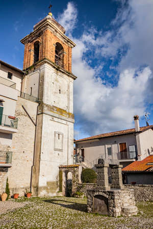The small medieval village of Castel San Pietro Romano, Lazio, province of Rome, Palestrina. A glimpse of the town, with the small cobbled square. The ancient water well and the church bell tower.の写真素材