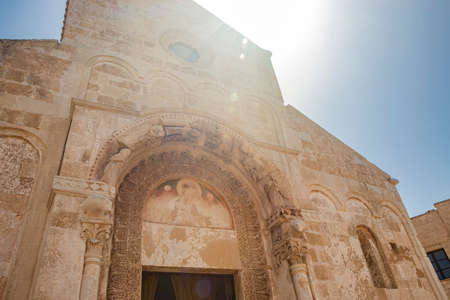 August 10, 2021 - Abbey of Santa Maria a Cerrate, Puglia, Salento, Lecce - Ancient Romanesque church, heritage of the FAI. The facade with the large arch above the portal and the columns on the sides.のeditorial素材