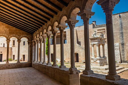 August 10, 2021 - Abbey of Santa Maria a Cerrate, Puglia, Salento, Lecce - The portico at the side of the church, shady and cool, with arches and columns. Shelter from the sun and the summer heat.のeditorial素材
