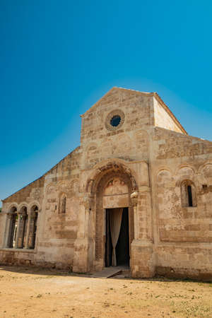 August 10, 2021 - Abbey of Santa Maria a Cerrate, Puglia, Salento, Lecce - Ancient Romanesque church, heritage of the FAI. The facade with the large arch above the portal and the columns on the sides.のeditorial素材