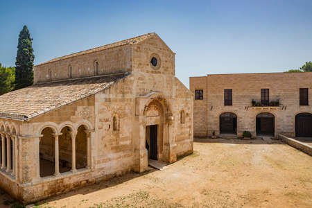 August 10, 2021 - Abbey of Santa Maria a Cerrate, Puglia, Salento, Lecce - The portico at the side of the church, shady and cool, with arches and columns. Shelter from the sun and the summer heat.のeditorial素材