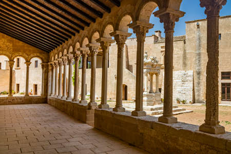August 10, 2021 - Abbey of Santa Maria a Cerrate, Puglia, Salento, Lecce - The portico at the side of the church, shady and cool, with arches and columns. Shelter from the sun and the summer heat.のeditorial素材