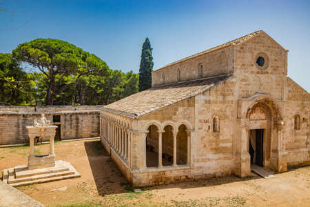 August 10, 2021 - Abbey of Santa Maria a Cerrate, Puglia, Salento, Lecce - The portico at the side of the church, shady and cool, with arches and columns. Shelter from the sun and the summer heat.のeditorial素材