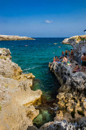 Aug 17, 2021 - Otranto, Puglia, Italy - The small beach of Porto Badisco, famous seaside resort of Salento. Tourists spend their summer holidays. People have fun and swim in the sea.のeditorial素材