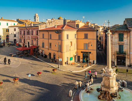 Feb. 6, 2022 - Tarquinia, Viterbo, Lazio, Italy - The main square of the village photographed from above, in the evening. Circular fountain with the obelisk. The light of the waning sun at sunset.のeditorial素材