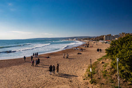 March 14, 2022 - Santa Marinella, Rome, Lazio, Italy - The seaside castle of Santa Severa on a winter day. The rough sea, wind, the cloudy blue sky. Many people stroll and enjoy the sun on the beach.のeditorial素材