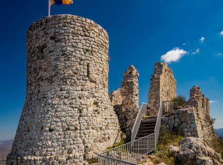 The small village of Tolfa, in Lazio. Remains of the ancient walls of the fortress on top of the cliff. Ruins of the castle. The tower where the flag of Ukraine is hoisted as a sign of solidarity.の写真素材