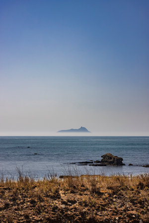 Ponza, Italy. The silhouette of the island emerging from the fog, seen from the Lazio coast in the distance.の写真素材