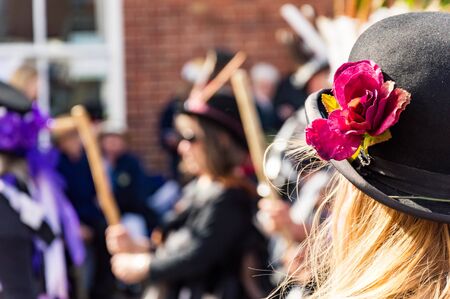 4th May 2019, Upton Upon Severn, UK. A close up of a woman wearing a bowler hat. With morris dancers blurred in the background at the Upton Folk Festivalの写真素材