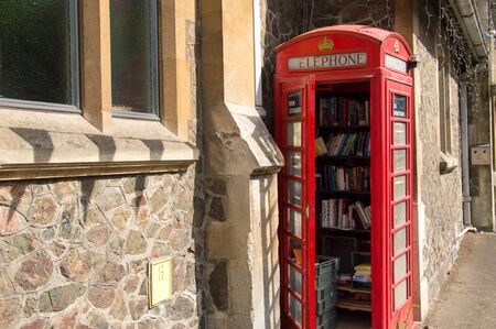 An old red telephone box, used as a community library, Malvern, Worcestershire, UK.
