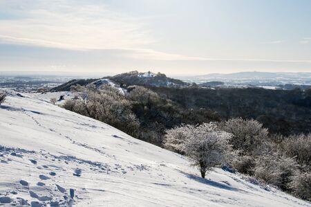 The ridge of the Malvern Hills covered in snow on a sunny winters dayの写真素材