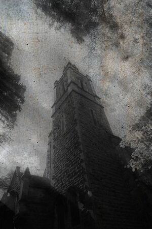 Looking up at a spooky church tower. With a grunge, textured, blurred edit.の写真素材