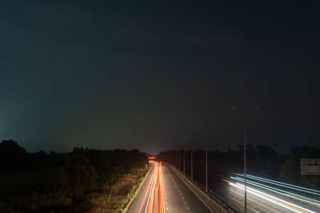 traffic trails at night on a motorway going across the countrysideの写真素材
