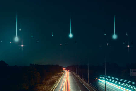 traffic trails at night on a motorway going across the countryside. As UFO's fall from the skyの写真素材