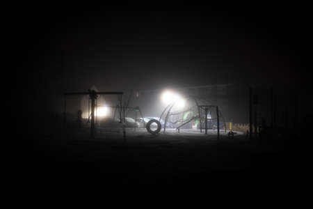 An empty spooky playground. On a atmospheric winters nightの写真素材