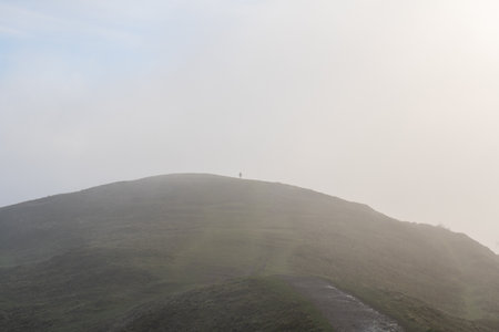 A lone figure on top of a hill. On a misty winters dayの写真素材