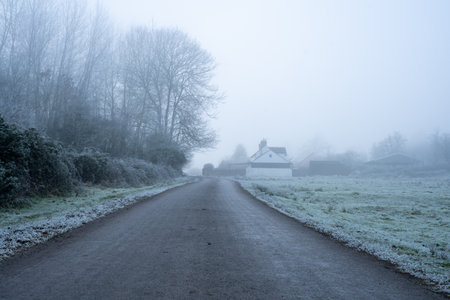 A road heading into the distance. On an atmospheric frosty winters day. Castlemorton Common. UK.の写真素材