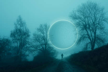 A glowing, portal, gateway on a countryside track, on a spooky, foggy, winters evening. With a blurred magical edit.の写真素材